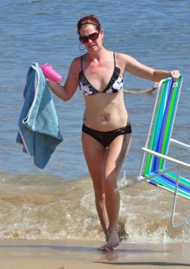 Tattooed redhead milf in a bikini at the beach