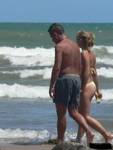 Sexy blonde on the beach in a yellow thong bikini