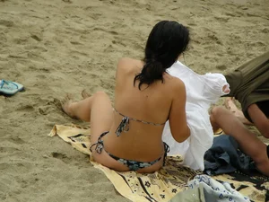 Sexy girl in a blue floral thong bikini at the beach