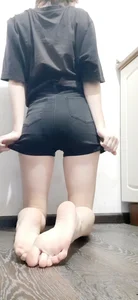 Barefoot Girl Skinny in Black Shorts Standing on Her Knees on the Floor Selfie