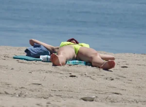 Sexy ass blonde milf on the beach in a thong with cameltoe and bending over