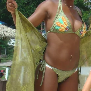 Sexy black babe in various bikinis on the beach while on vacation