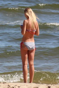 Beautiful skinny blonde babe with cute ass in bikini on the beach