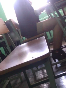 Slim College Girl in a Skirt And High-Heeled Shoes Sitting at a Desk Creepshot