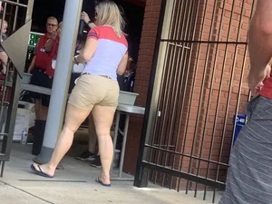 Bunch of girls in various outfits at a Cardinals baseball game