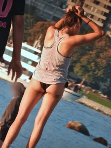 Sexy beach girl in a Nike sports bra and black bikini bottom