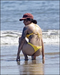 Sexy tattooed beach brunette with a great ass in yellow thong bikini