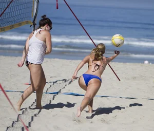 Hot girls playing beach volleyball in bikinis and shorts