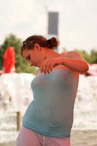 Big boobed girl in blue top with no bra playing in the water