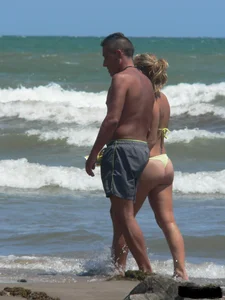 Sexy blonde on the beach in a yellow thong bikini
