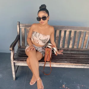 Non-candid girl in a top and short skirt sitting on a bench with crossed legs with her panties almost flashing