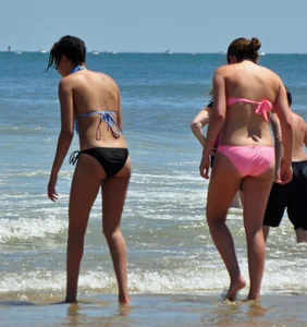 Two teen friends in bikinis at the beach