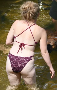 Chunky blonde enjoying some drinks in the water in her purple bikini