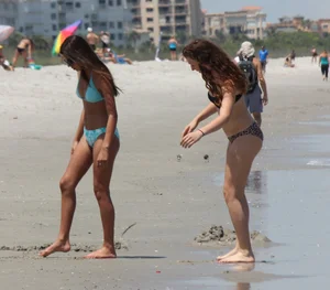 Brunette and redhead on the beach in bikinis looking sexy