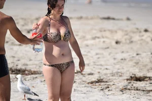 Brunette on the beach in a cheetah print bikini
