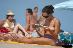 2 topless girls at the beach in thongs