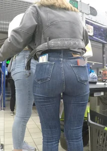 Two hot milfs in tight blue jeans standing at the cash register at the supermarket, awesome big butts