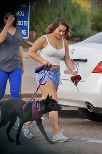 Sexy dog walker in shorts and tank top with friend in blue jeans