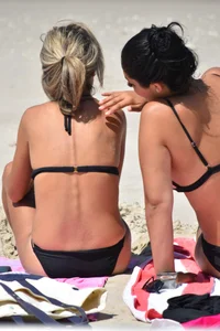 Blonde and brunette on the beach looking sexy in their bikinis