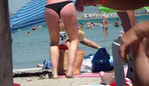 Amazing ass in semi-thong bikini on the beach with tanlines