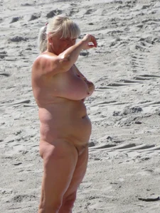 Mature blonde lady on a nude beach with big boobs