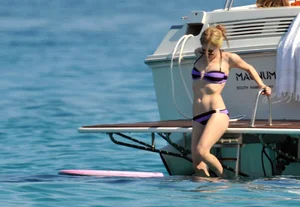 Avril Lavinge looking sexy in purple bikini on a boat