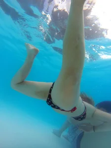 Underwater shots of a bikini teen swimming in the pool