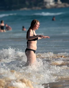 Cute bikini girl in the water in a black bikini