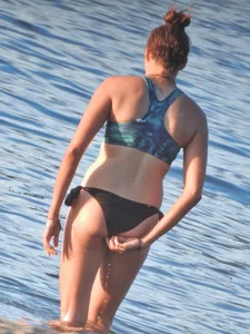 Sexy beach girl in a Nike sports bra and black bikini bottom