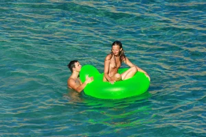 FKK Nudists playing in the water with floater