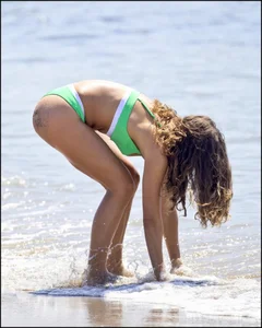 Super hot beach babe with a perfect body in a green thong bikini
