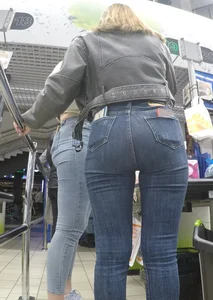 Two hot milfs in tight blue jeans standing at the cash register at the supermarket, awesome big butts