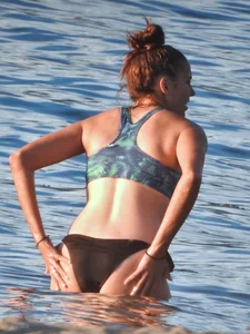Sexy beach girl in a Nike sports bra and black bikini bottom