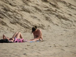 Topless beach girl with nice titties with her friend in a bikini