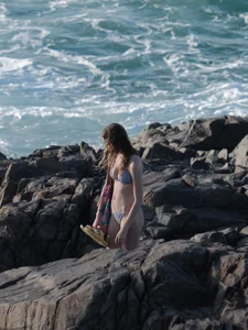 Beautiful bikini girl on the rocks at the beach