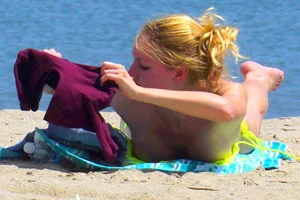 Sexy ass blonde milf on the beach in a thong with cameltoe and bending over