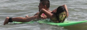 Brunette bikini girl on the beach and surfing in her bikini