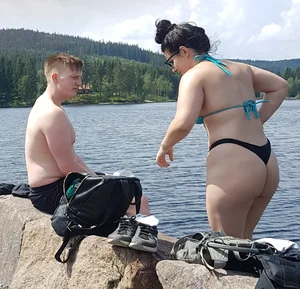 Thick brunette at the lake in a black thong bikini