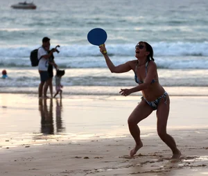 Older lady playing on the beach in her bikini