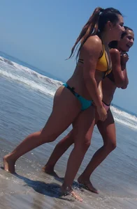2 beach friends in bikinis,one thick and in a thong