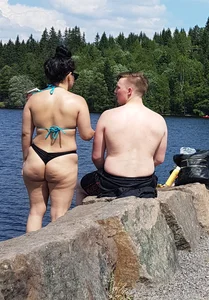 Thick brunette at the lake in a black thong bikini