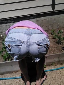 Girl Bending Over in a Garden - Dowblouse and Ass in Denim Shorts