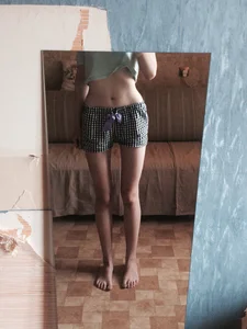 Girl with Skinny Legs and Thin Waistline in Shorts and a Top Home Mirror Selfie