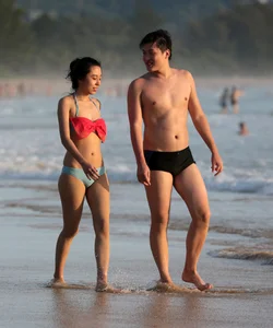Cute Asian in bikini on the beach with her boyfriend