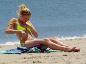 Sexy ass blonde milf on the beach in a thong with cameltoe and bending over