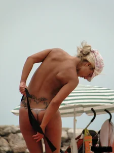 Tattooed blonde with big tits topless and in thong