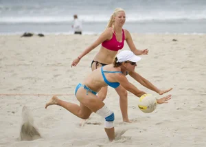 Hot girls playing beach volleyball in bikinis and shorts