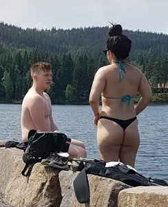 Thick brunette at the lake in a black thong bikini