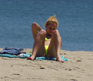 Sexy ass blonde milf on the beach in a thong with cameltoe and bending over