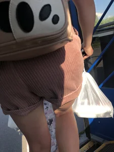 Young Girl in Sandals and Shorts in a Public Bus